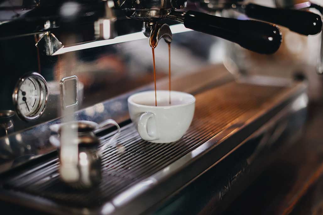 Machine brewing coffee into a mug.