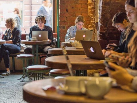 People working on their laptops inside a coffee shop.